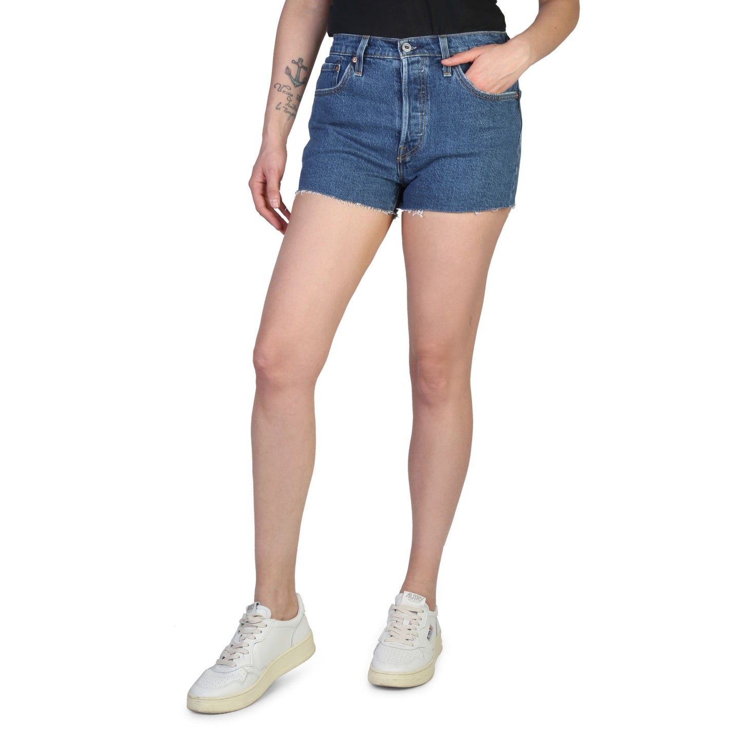Levis women's shorts in blue denim worn by a woman, casual summer outfit with white sneakers.