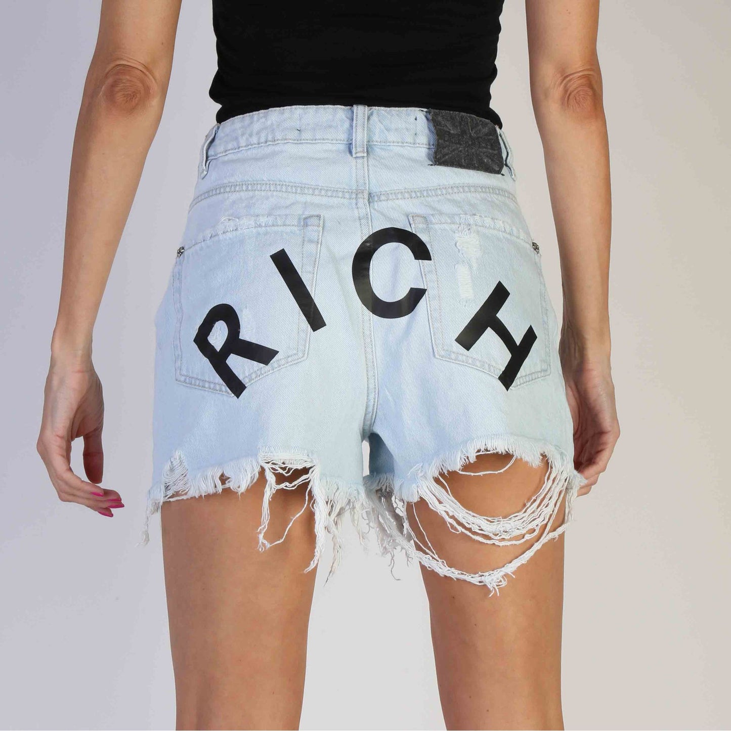 women's Richmond shorts featuring distressed hem and bold "RICH" print on the back, perfect for spring/summer fashion.