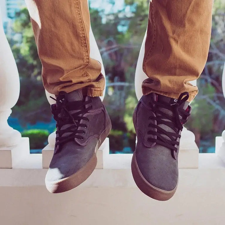 Men shoes showcased with stylish gray sneakers and casual pants against a scenic background.